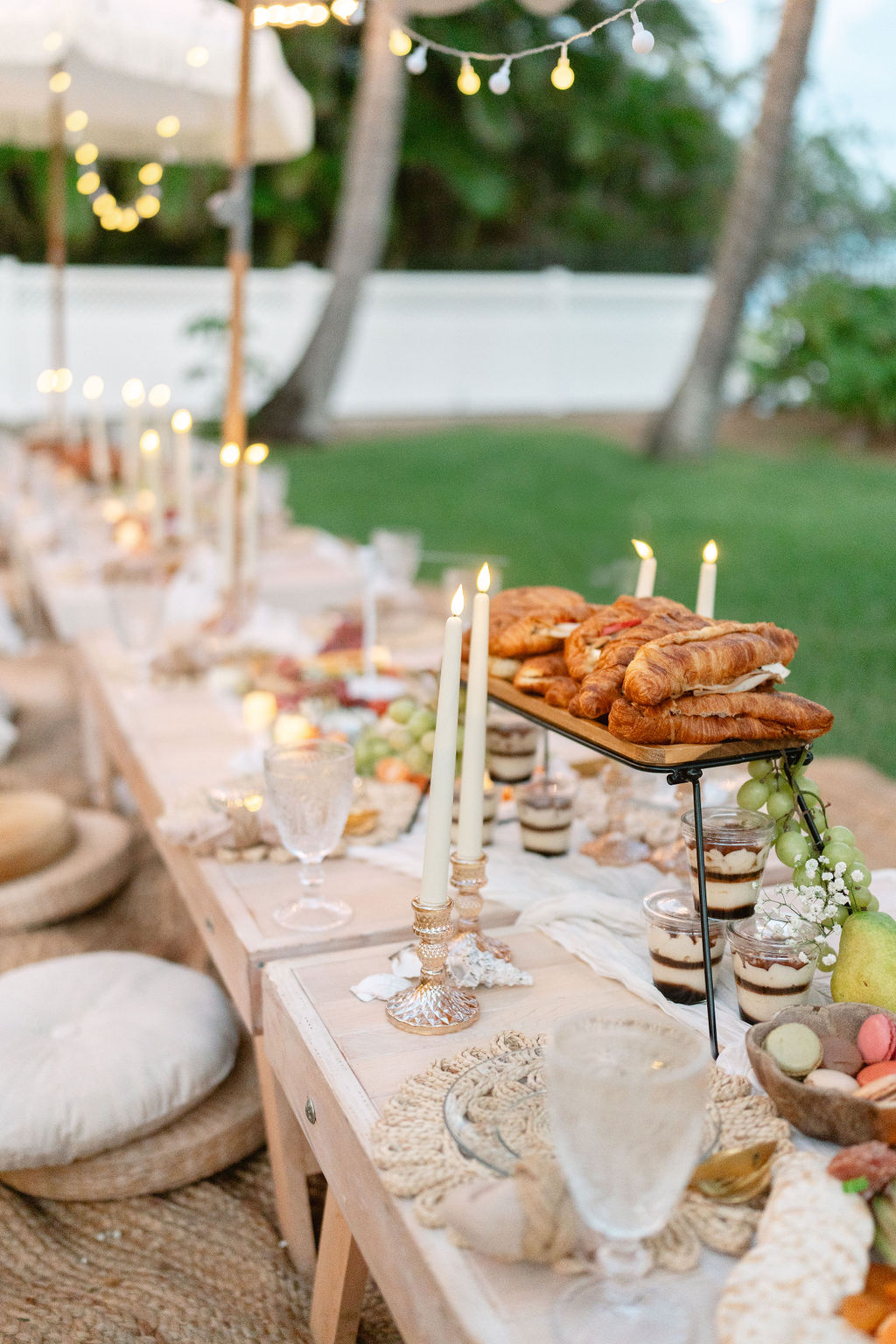 Outdoor dining table set with food, candles, and string lights for a micro wedding in oahu