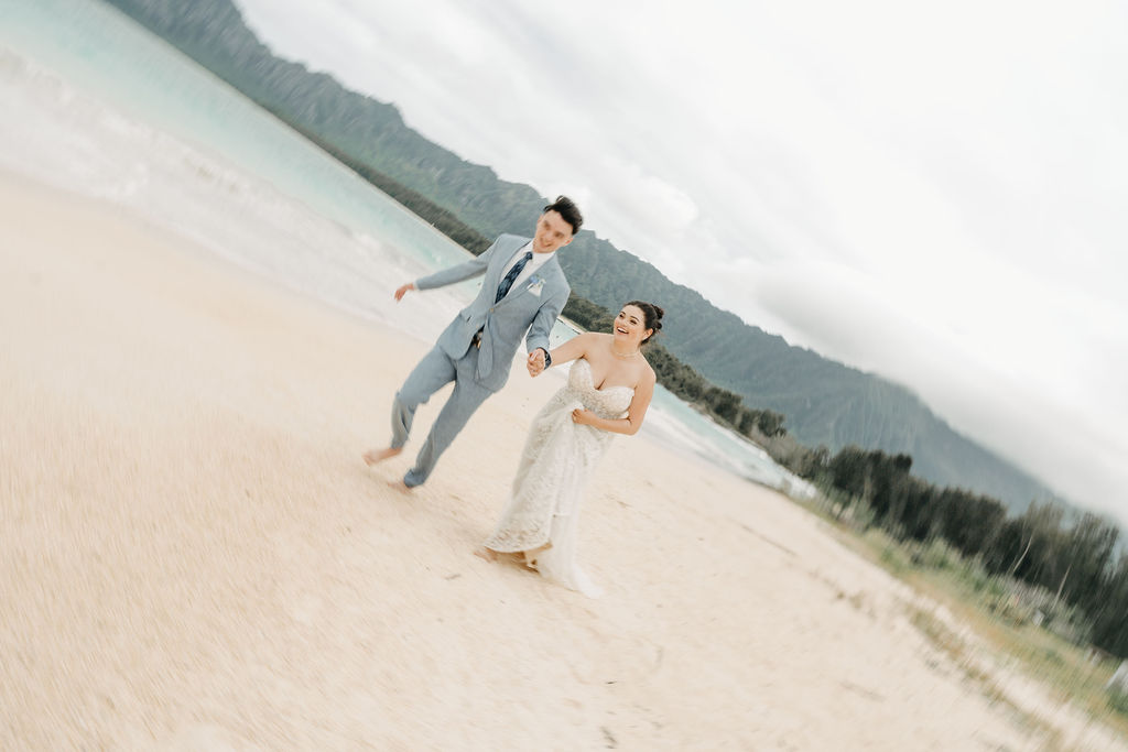 bride and groom take wedding portraits on the beach for their beach wedding in Oahu