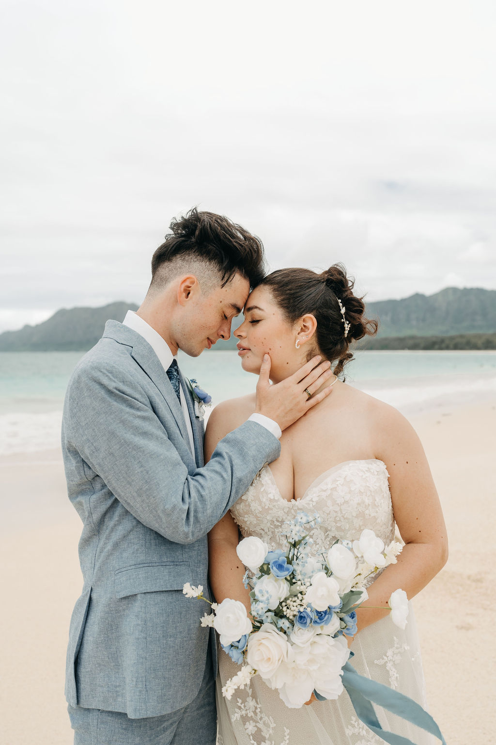 bride and groom take wedding portraits on the beach for their beach wedding in Oahu