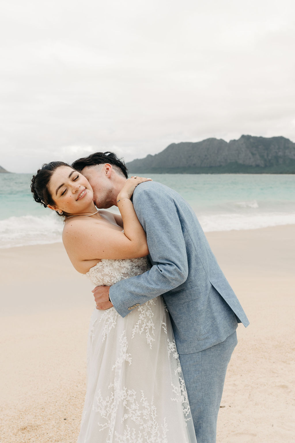 bride and groom take wedding portraits on the beach for their beach wedding in Oahu