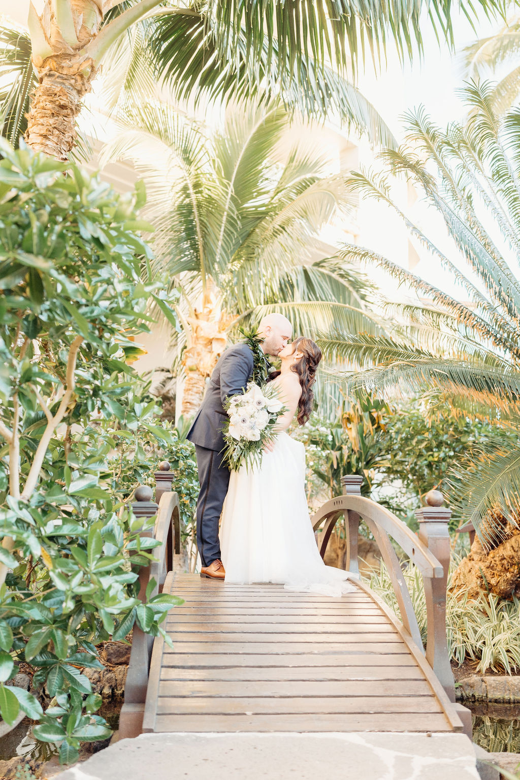 bride and groom take sunset portraits for the wedding at the four seasons in oahu