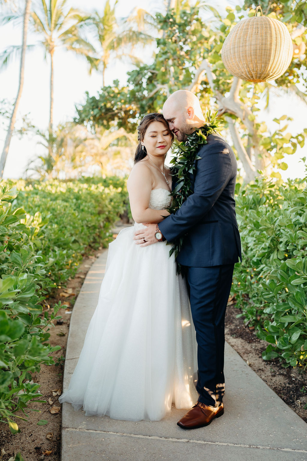 bride and groom take sunset portraits for the wedding at the four seasons in oahu