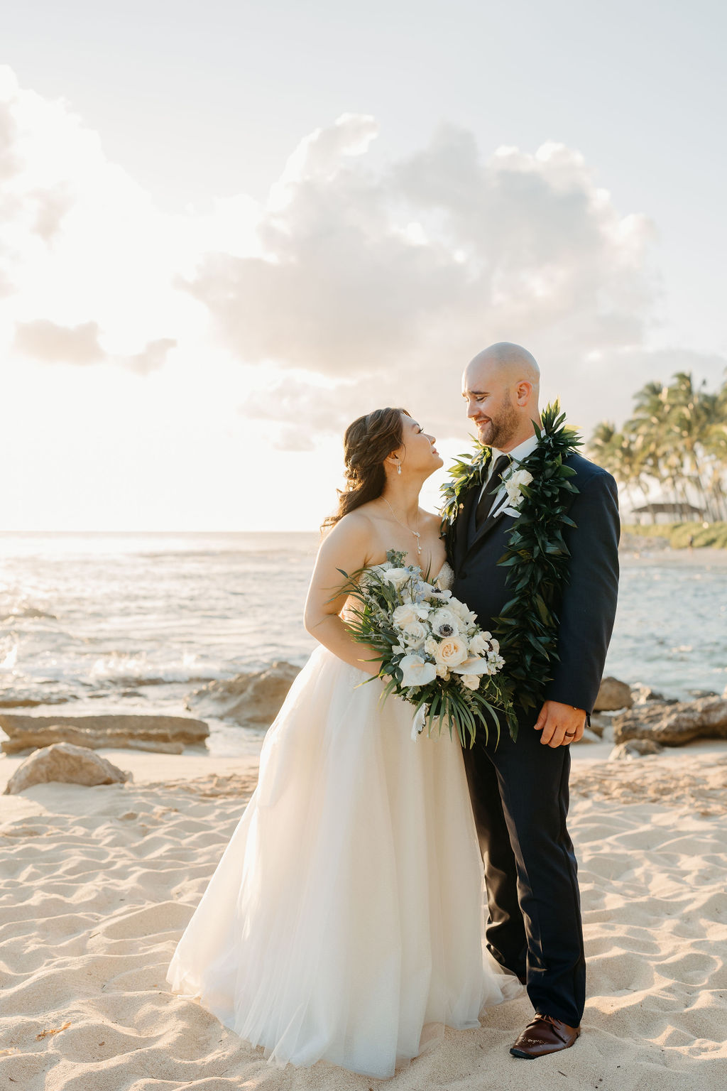 bride and groom take sunset portraits for the wedding at the four seasons in oahu