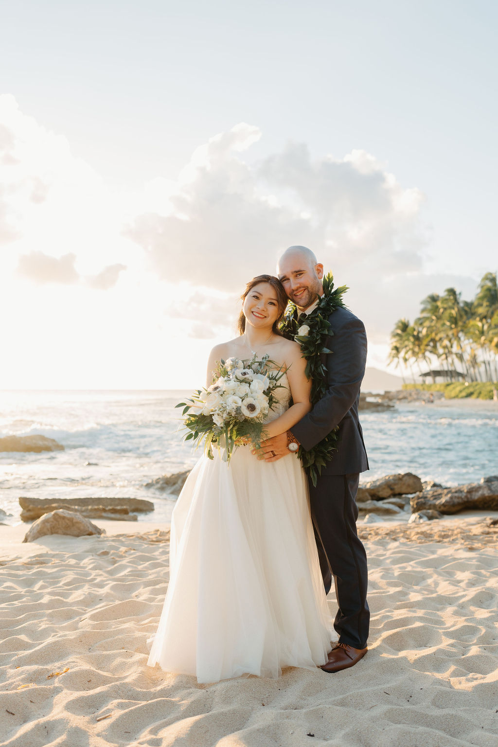 bride and groom take sunset portraits for the wedding at the four seasons in oahu