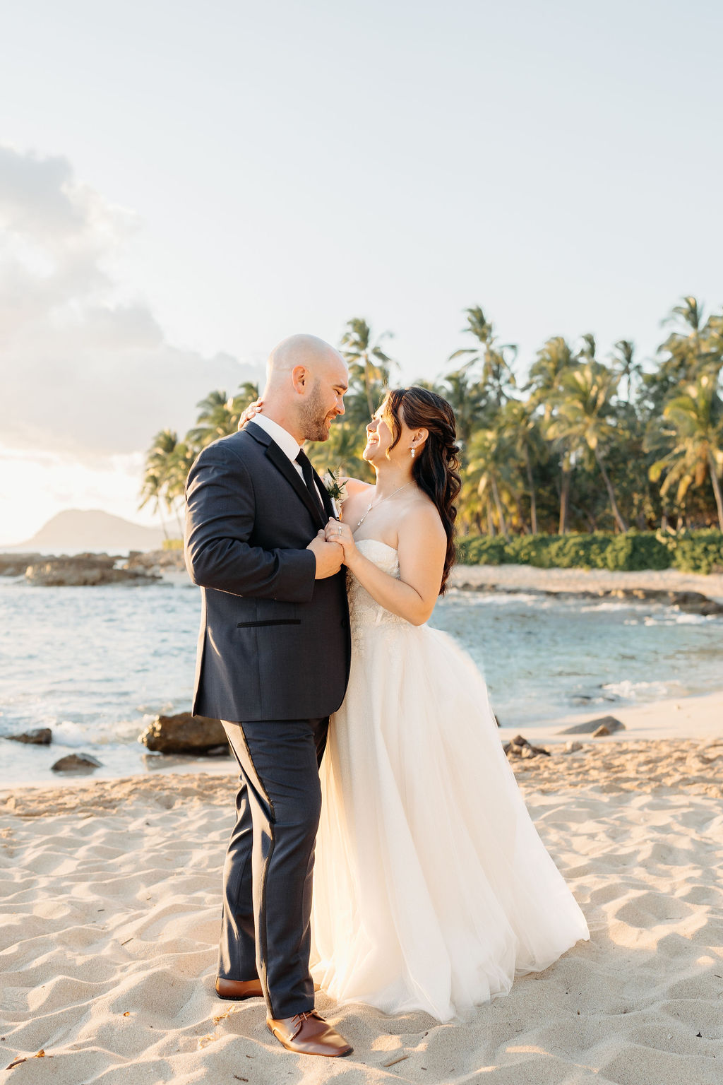 bride and groom take sunset portraits for the wedding at the four seasons in oahu