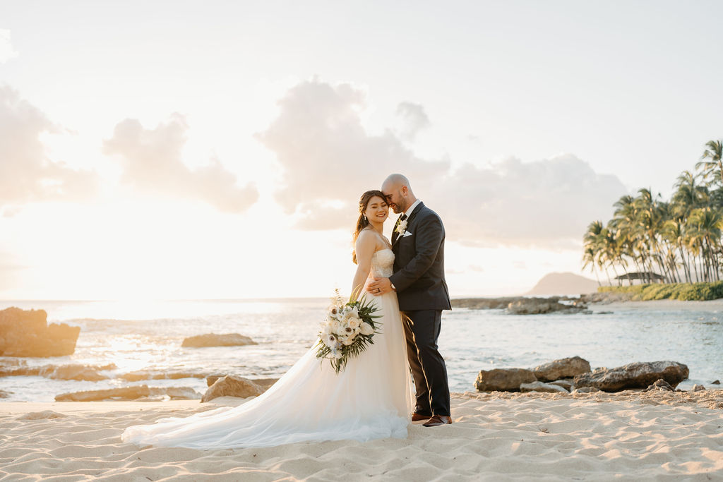 bride and groom take sunset portraits for the wedding at the four seasons in oahu