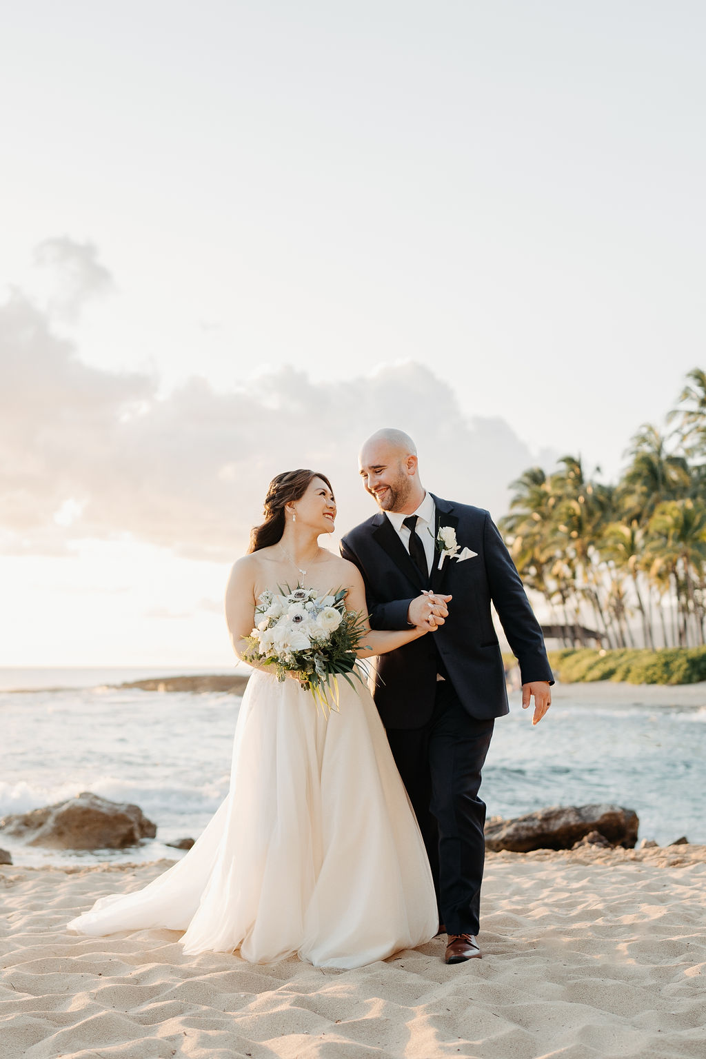 bride and groom take sunset portraits for the wedding at the four seasons in oahu