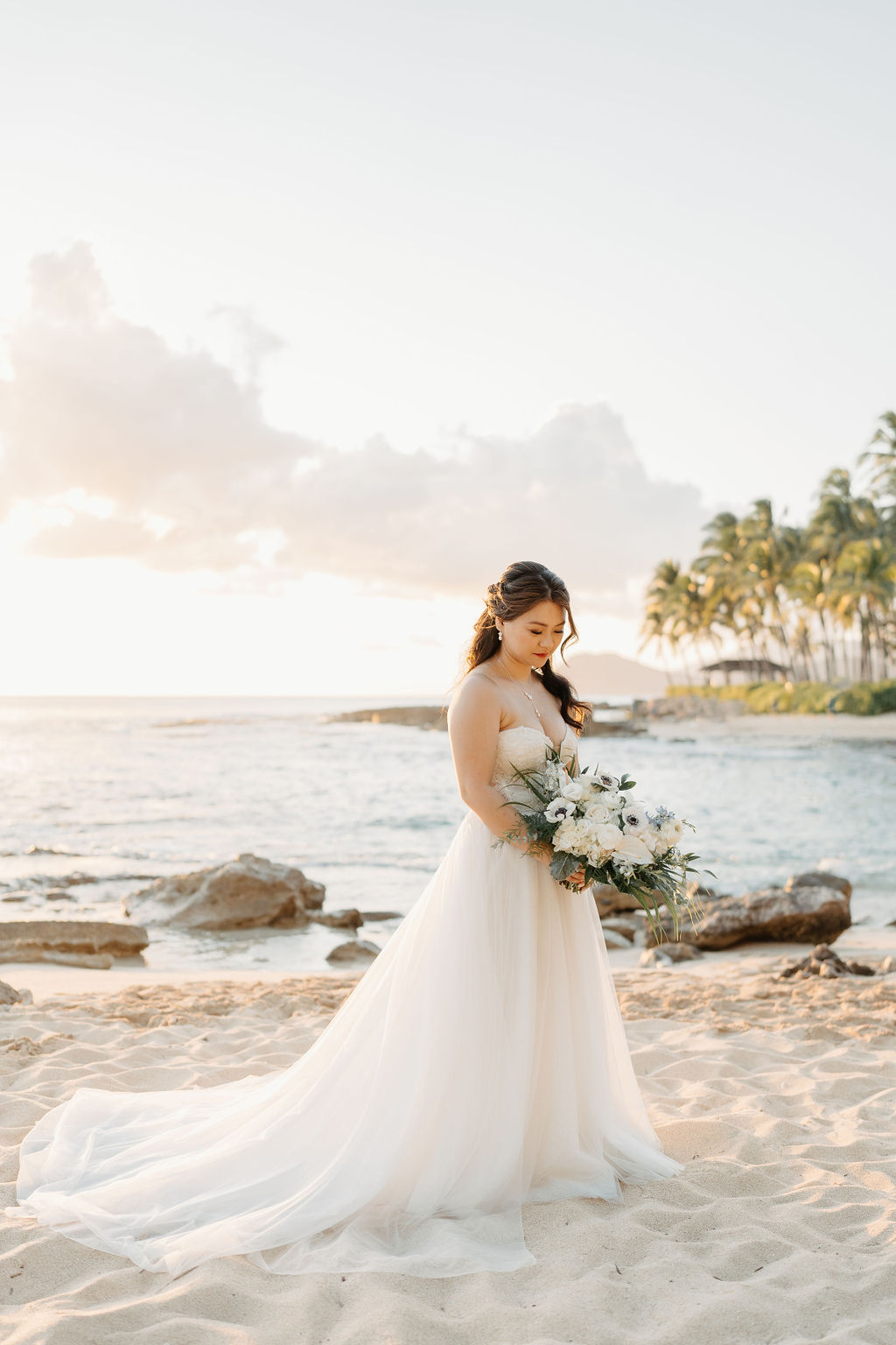 bride and groom take sunset portraits for the wedding at the four seasons in oahu