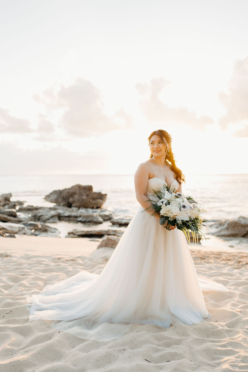 bride and groom take sunset portraits for the wedding at the four seasons in oahu