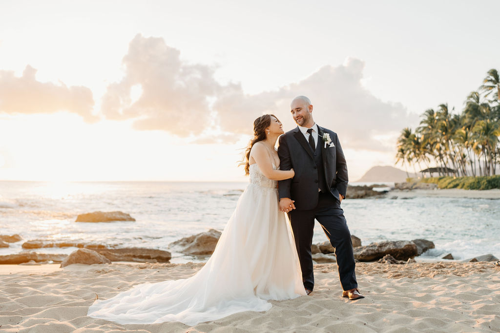 bride and groom take sunset portraits for the wedding at the four seasons in oahu