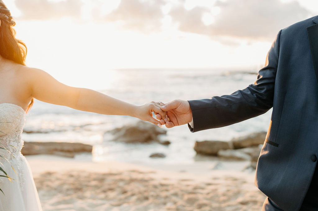 bride and groom take sunset portraits for the wedding at the four seasons in oahu