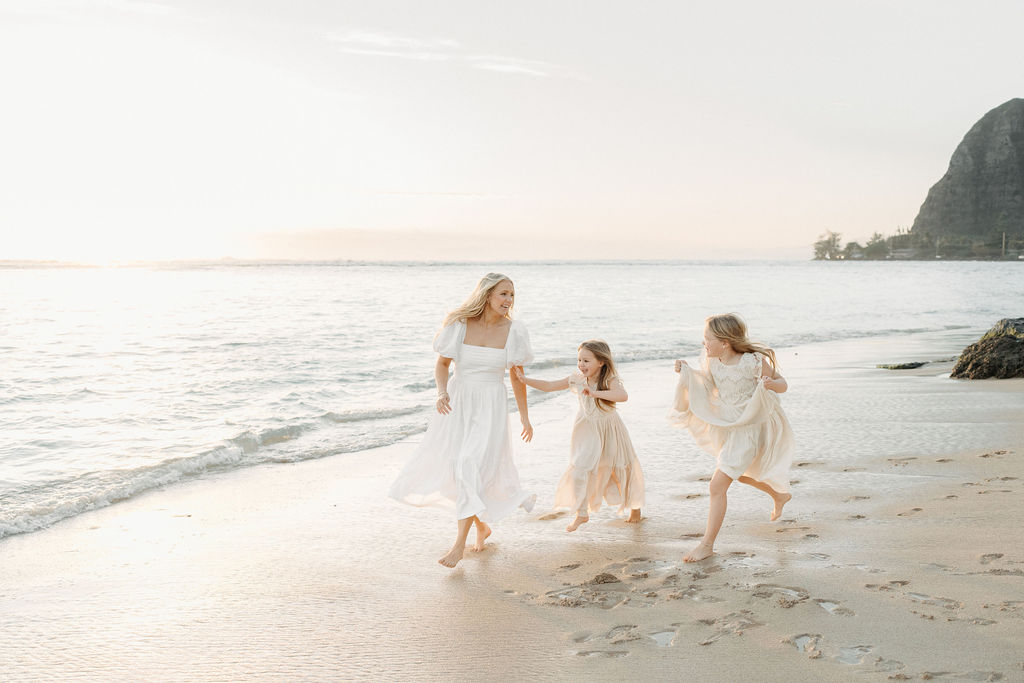 family taking family photos on the beach while on their family vacation to Oahu