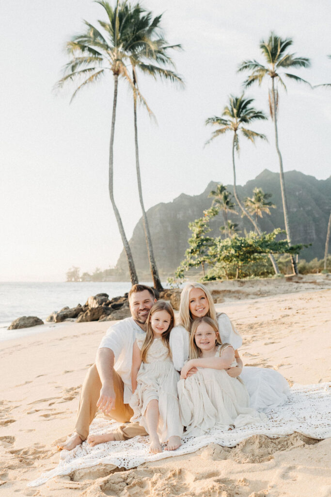 family taking family photos on the beach while their family vacation to Oahu