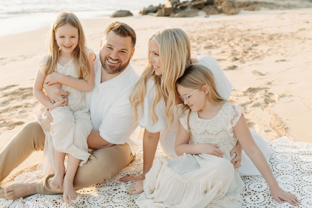 family taking family photos on the beach while their family vacation to Oahu