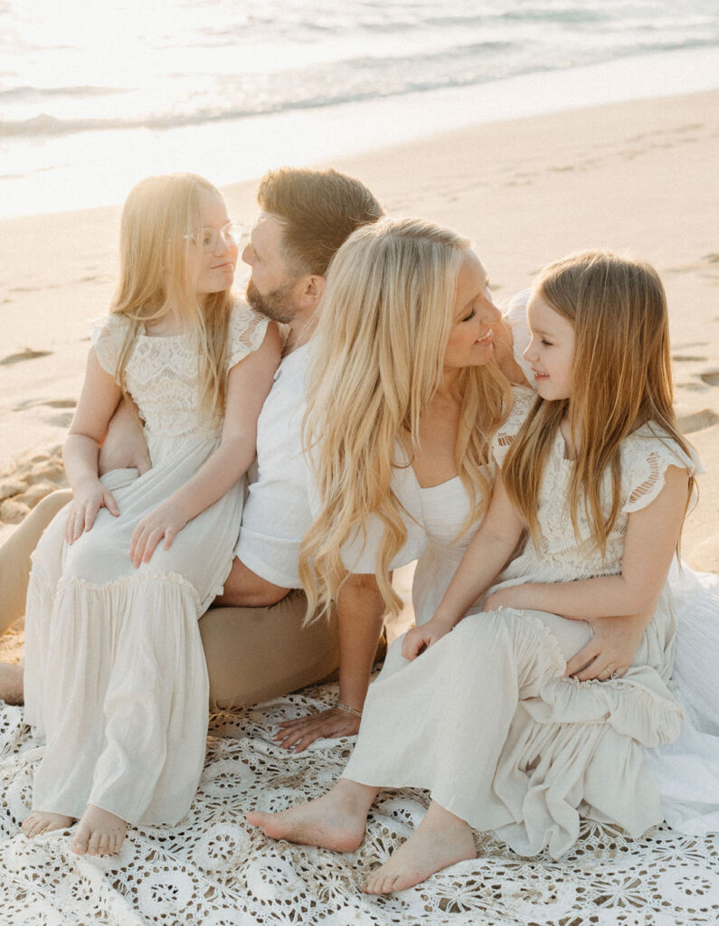 family taking family photos on the beach while their family vacation to Oahu