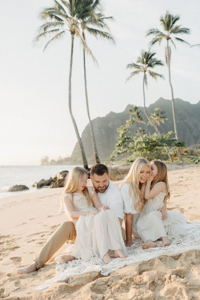 family taking family photos on the beach while their family vacation to Oahu