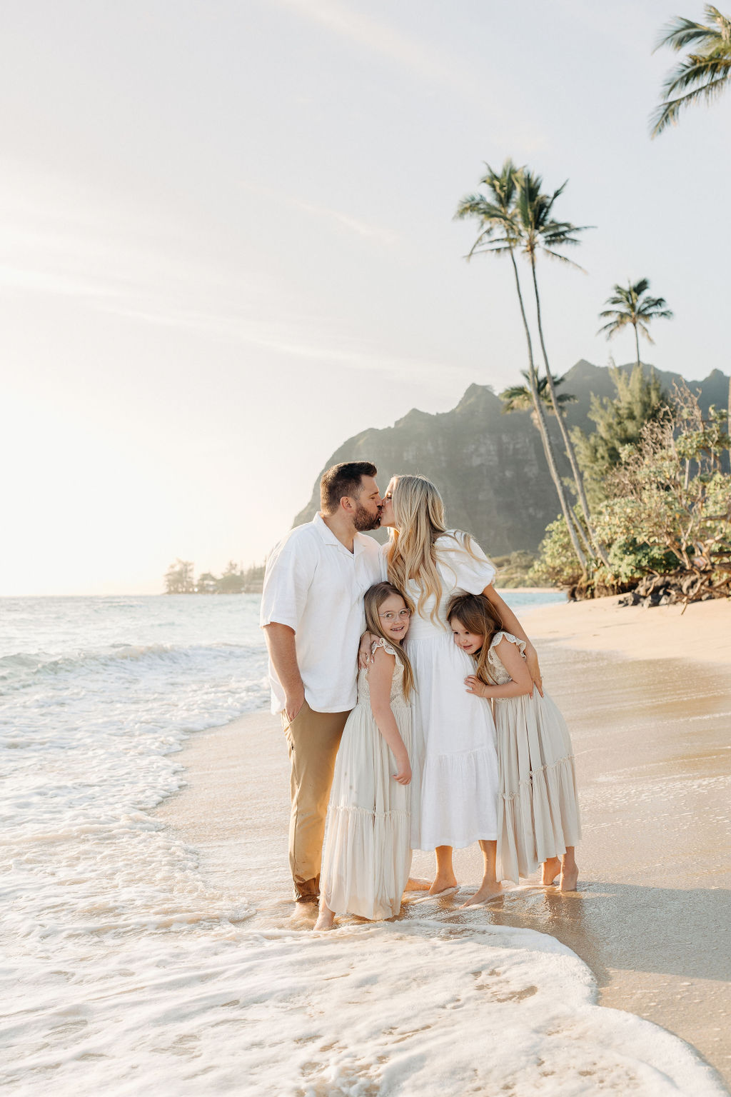 family taking family photos on the beach while their family vacation to Oahu