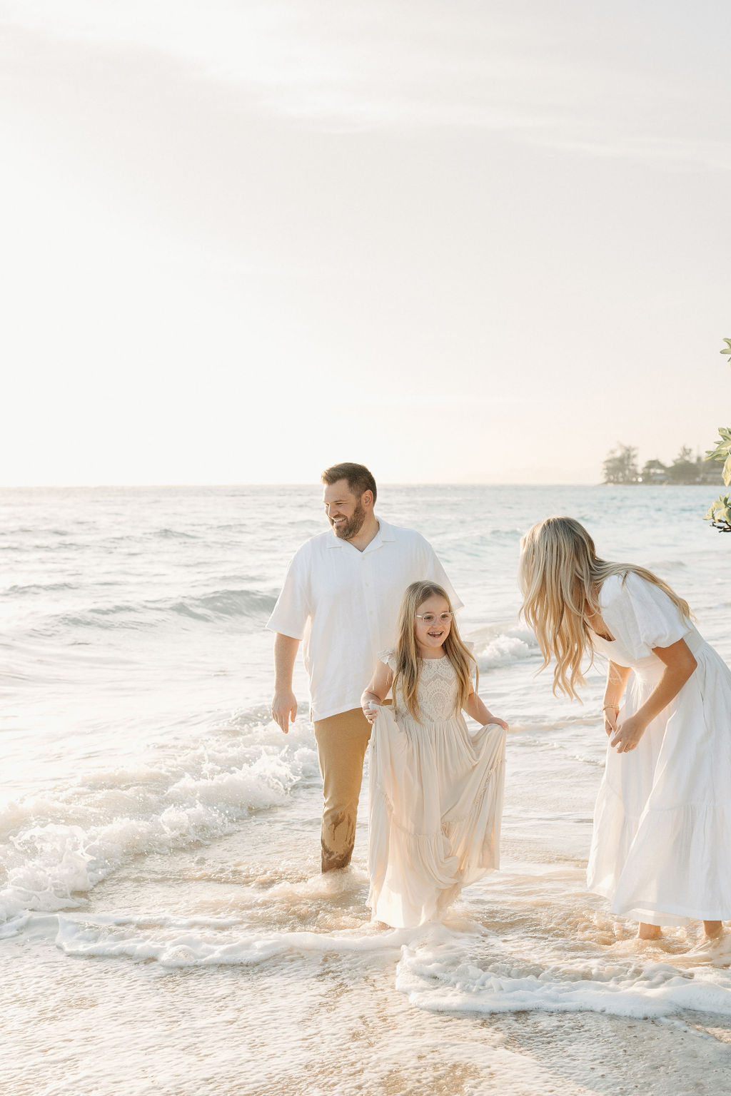 family taking family photos on the beach while their family vacation to Oahu