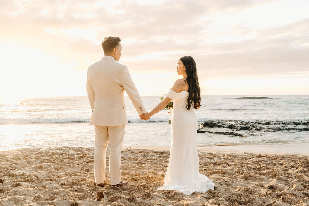 couple takes wedding portraits on a beach in oahu for their beach wedding ceremony