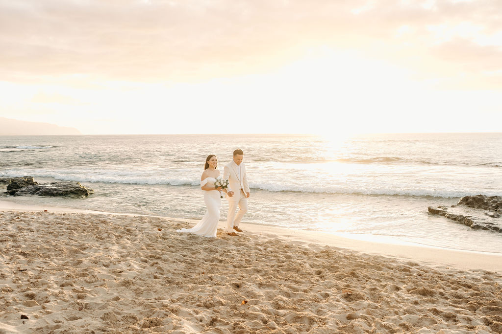 couple takes wedding portraits on a beach in oahu for their beach wedding ceremony