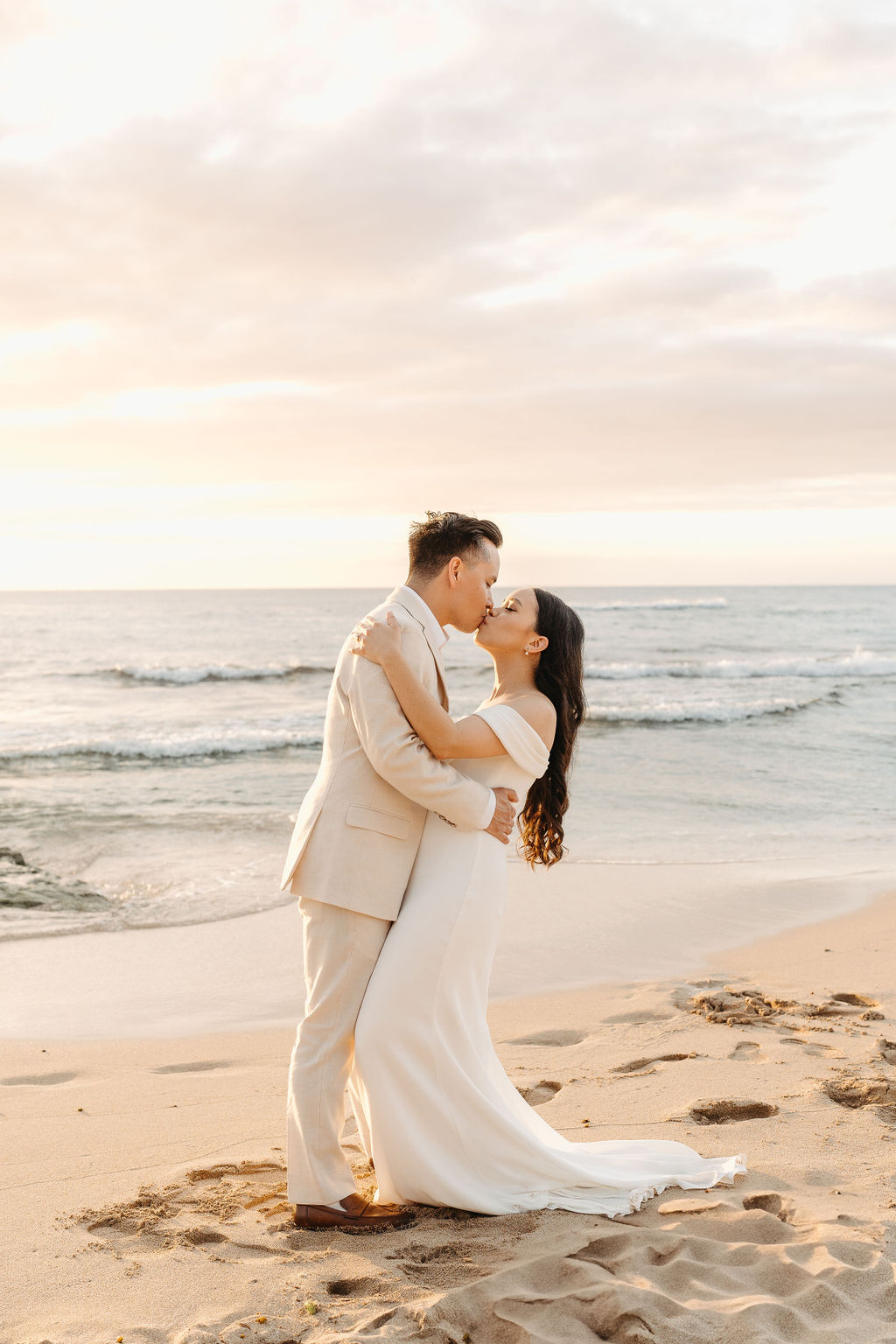 couple takes wedding portraits on a beach in oahu for their beach wedding ceremony