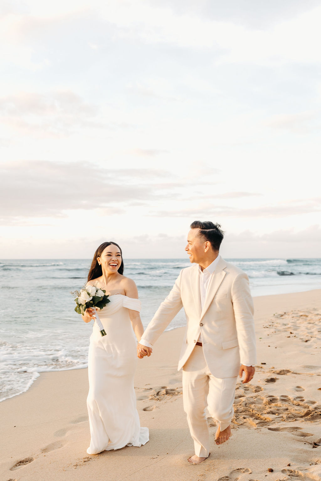 couple takes wedding portraits on a beach in oahu for their beach wedding ceremony