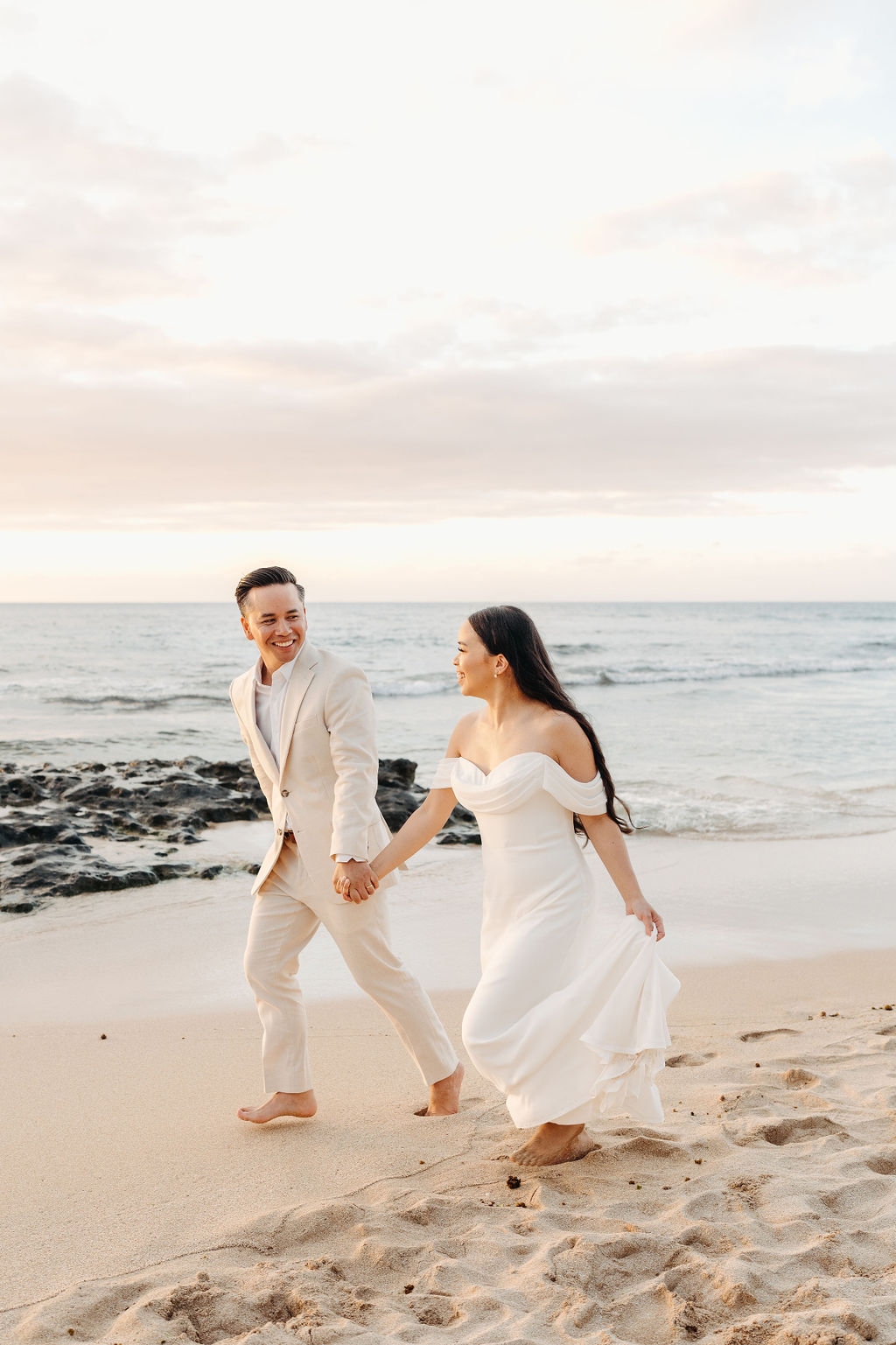 couple takes wedding portraits on a beach in oahu for their beach wedding ceremony