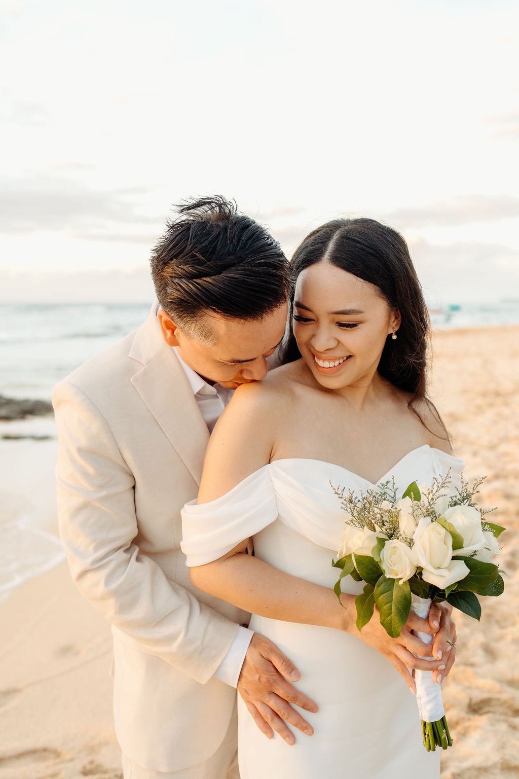 couple takes wedding portraits on a beach in oahu for their beach wedding ceremony