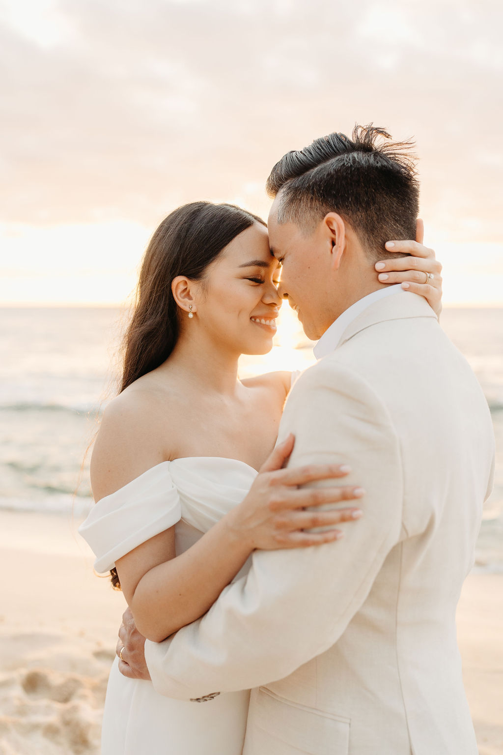 couple takes wedding portraits on a beach in oahu for their beach wedding ceremony