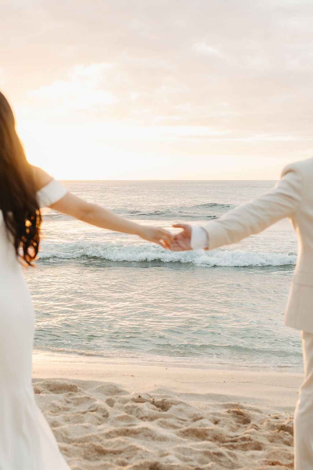 couple takes wedding portraits on a beach in oahu for their beach wedding ceremony