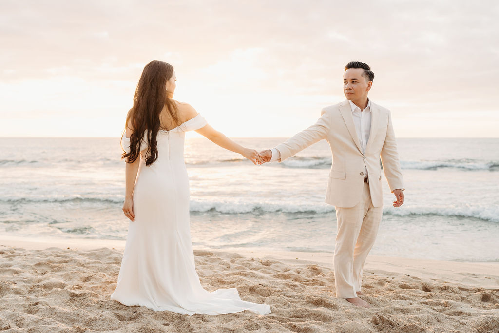 couple takes wedding portraits on a beach in oahu for their beach wedding ceremony