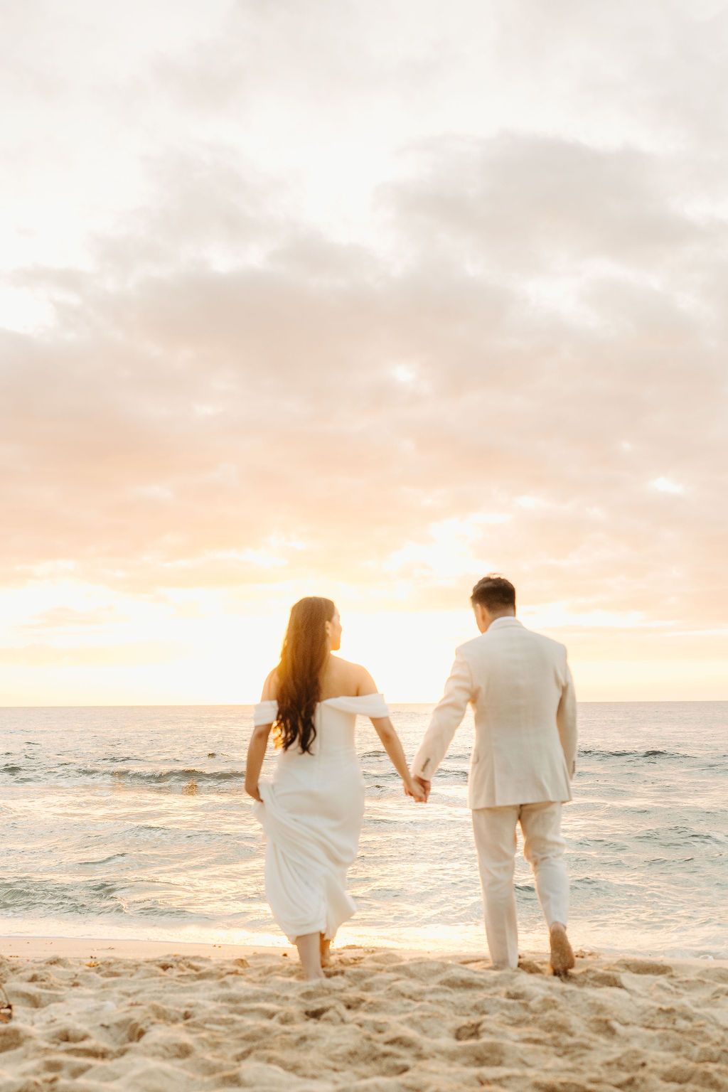 couple takes wedding portraits on a beach in oahu for their beach wedding ceremony