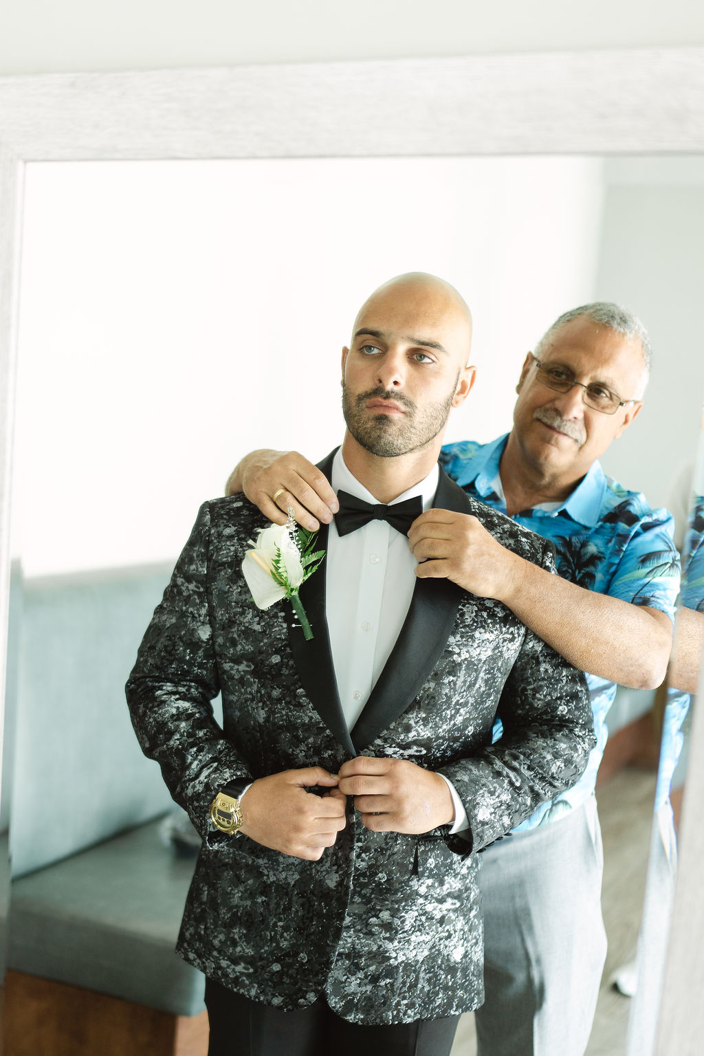 groom getting ready in a hotel room before her wedding in oahu hawaii