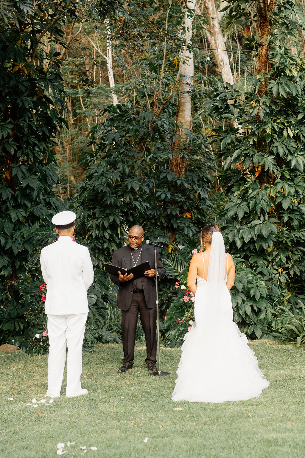 outdoor Backyard wedding ceremony in Oahu, couple stands at the end of the aisle