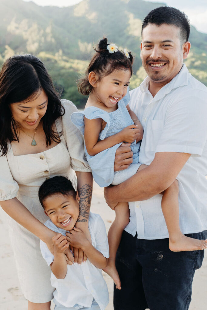 family takes fun photos on the beach for their oahu family portraits