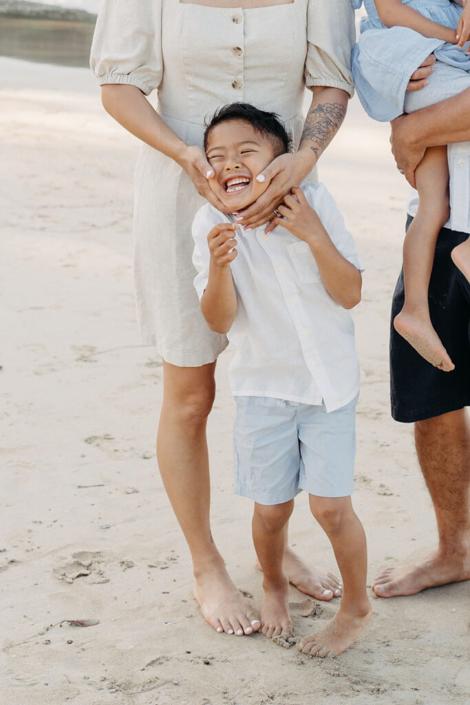 family takes fun photos on the beach for their oahu family portraits