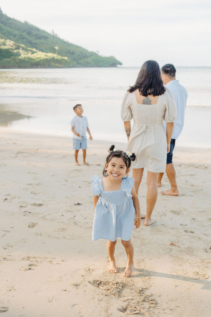 family takes fun photos on the beach for their oahu family portraits