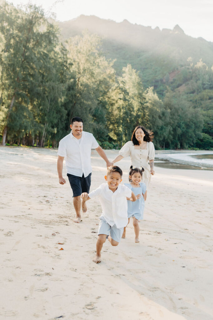 family takes fun photos on the beach for their oahu family portraits