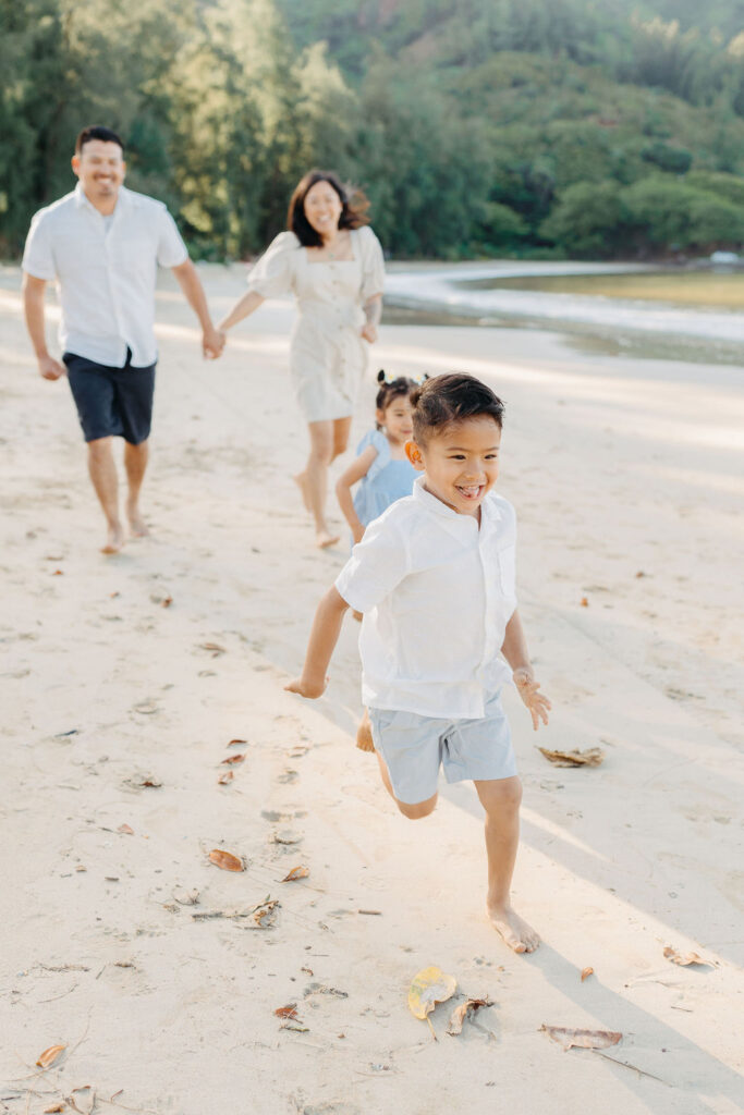 family takes fun photos on the beach for their oahu family portraits