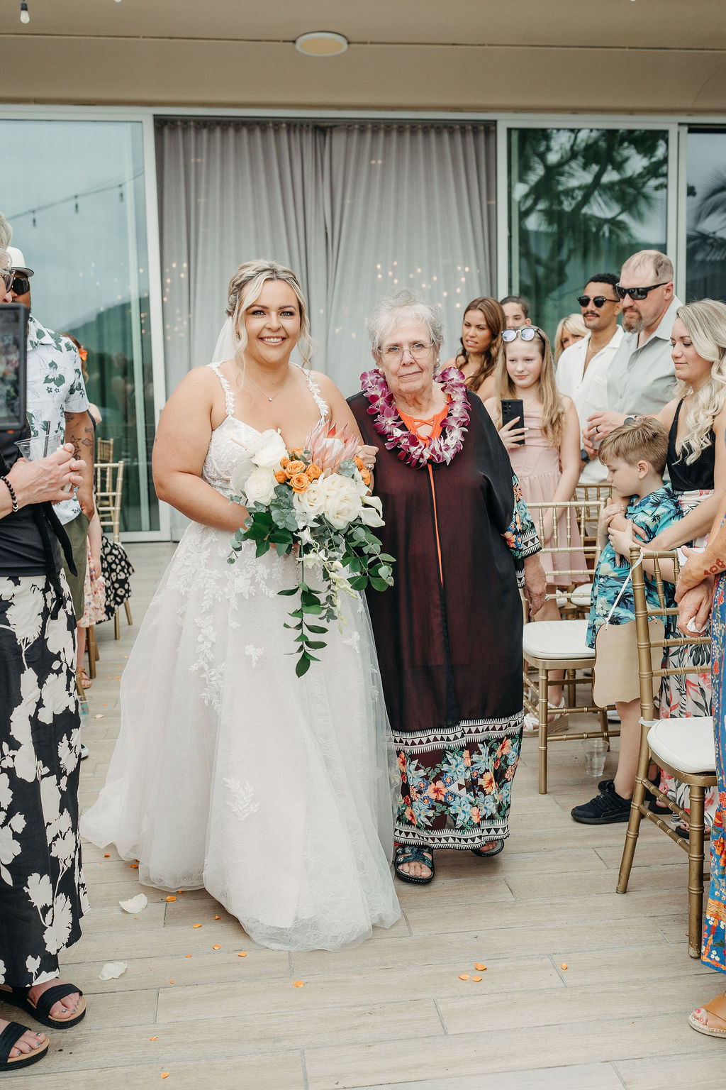 bride walks down the aisle with her mom for a wedding ceremony
