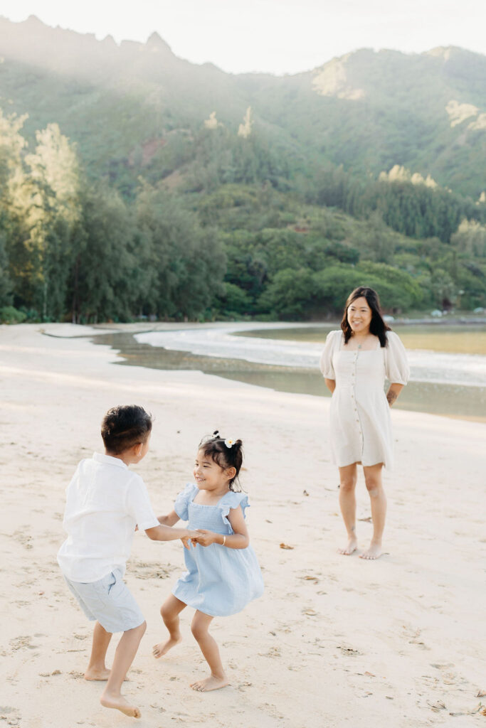family takes fun photos on the beach for their oahu family portraits