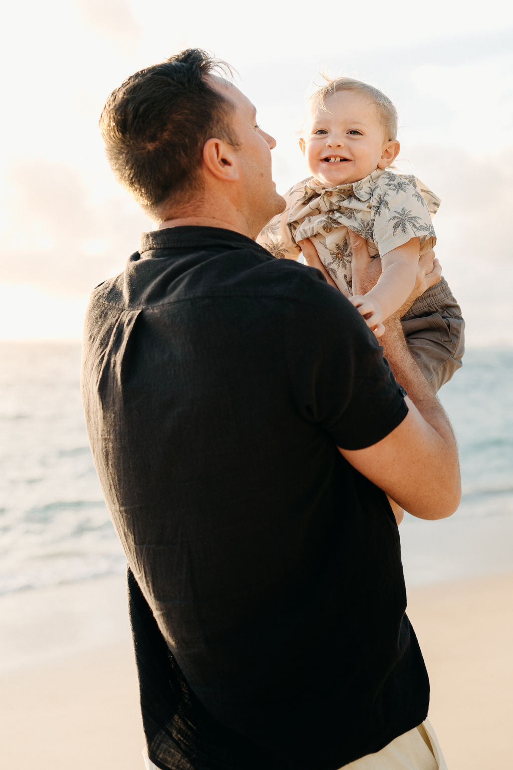 amily takes Hawaii family photos on Kaaawa beach at sunset with a toddler