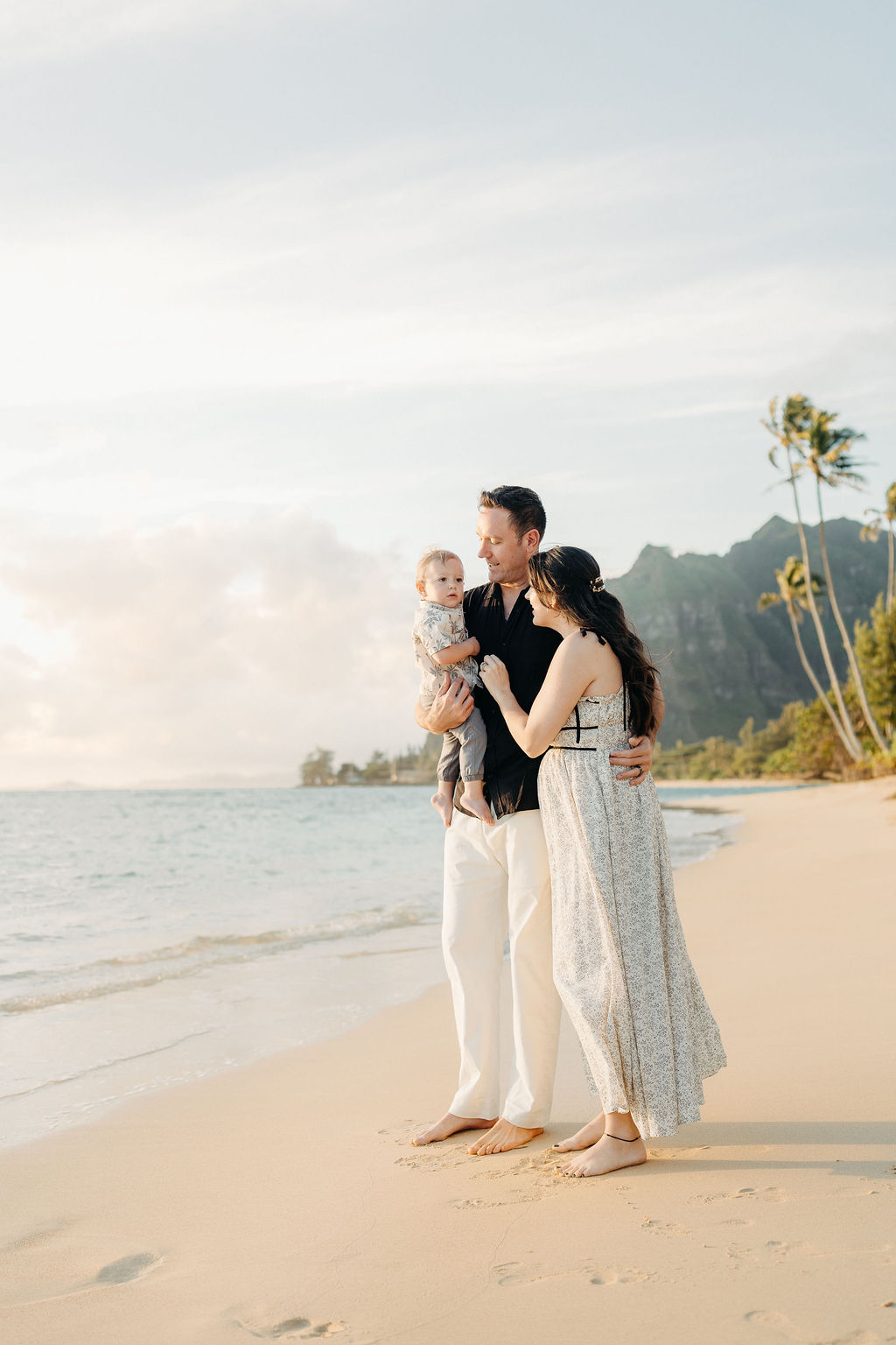 amily takes Hawaii family photos on Kaaawa beach at sunset with a toddler